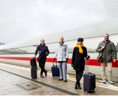 Vier Reisende mit Rollkoffern auf Bahnsteig vor vorbeifahrendem Hochgeschwindigkeitszug