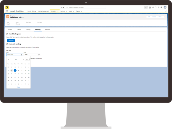 Ein Monitor zeigt die Inxmail-Integration in Salesforce auf der „Send“-Seite einer E-Mail-Kampagne mit dem Titel „Ladieswear July“. Die Benutzeroberfläche bietet die Option, das Mailing sofort zu versenden oder den Versand zu einem späteren Zeitpunkt zu planen. Ein Kalender zur Auswahl des Versanddatums ist geöffnet.