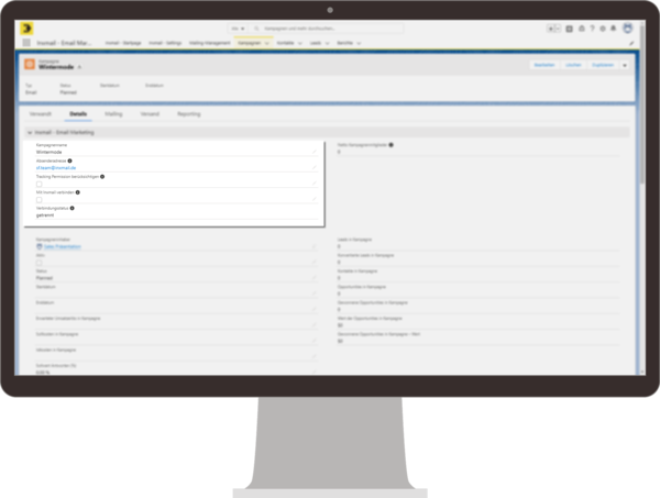 Monitor zeigt die Inxmail-Integration in Salesforce mit den Kampagneneinstellungen. Die Details zur Kampagne „Wintermode“ sind im Vordergrund zu sehen, einschließlich Optionen wie Versanddatum, Tracking-Permission und verschiedenen weiteren Kampagneneinstellungen.